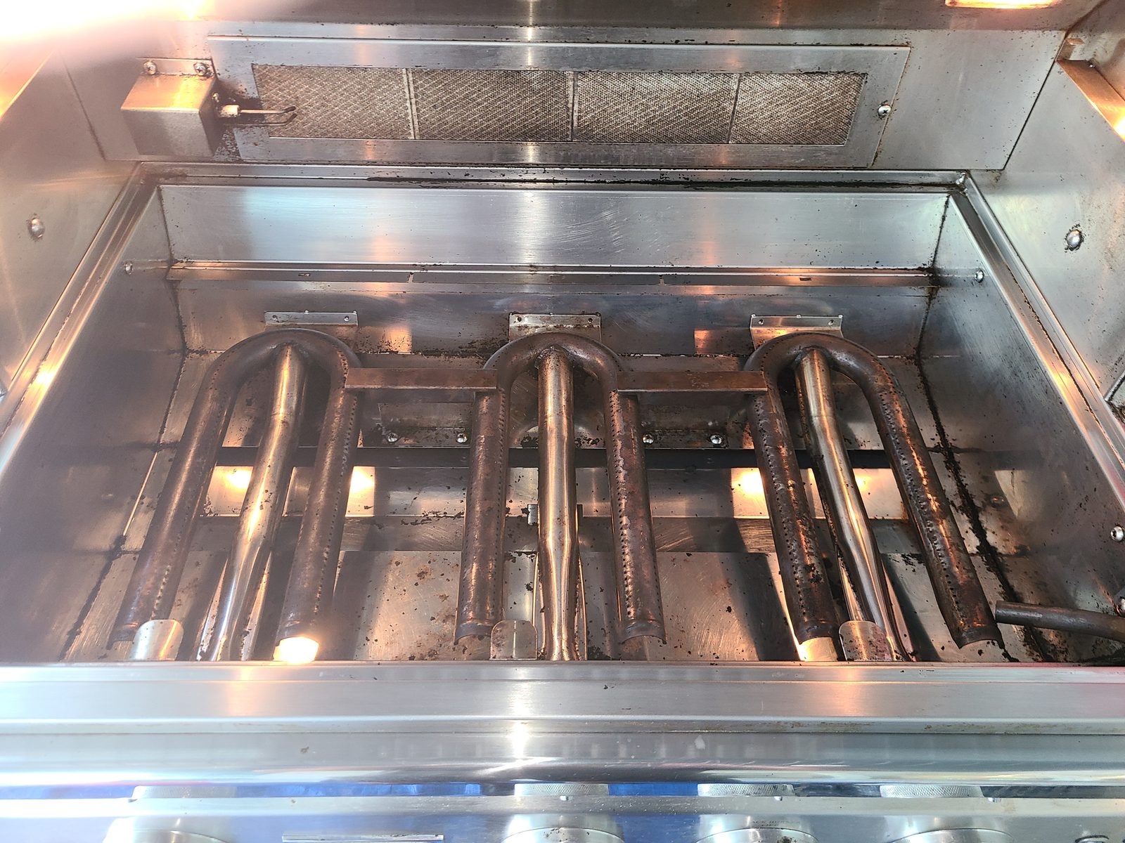 Luxury built-in grill burner chamber restored to polished stainless steel after professional cleaning by Xtreme Grill Clean Bradenton FL