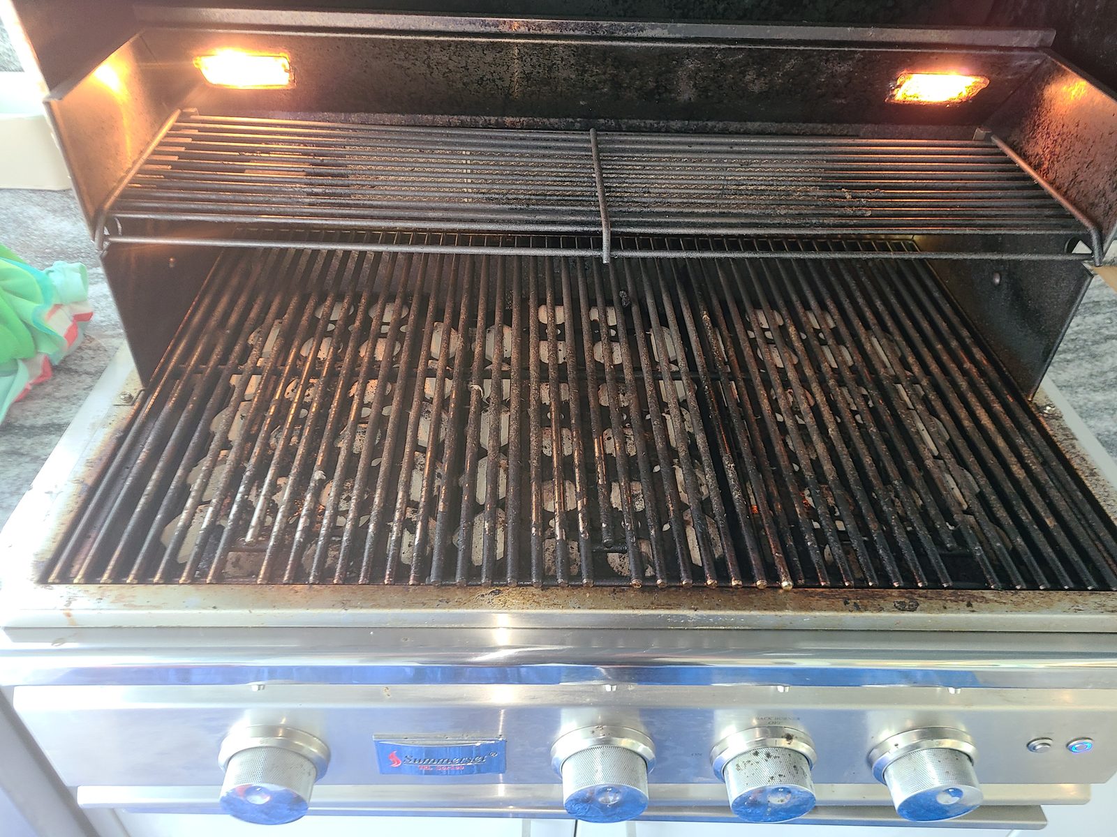 Summerset built-in grill with heavily soiled grates and carbon buildup before professional BBQ cleaning service in Lakewood Ranch FL