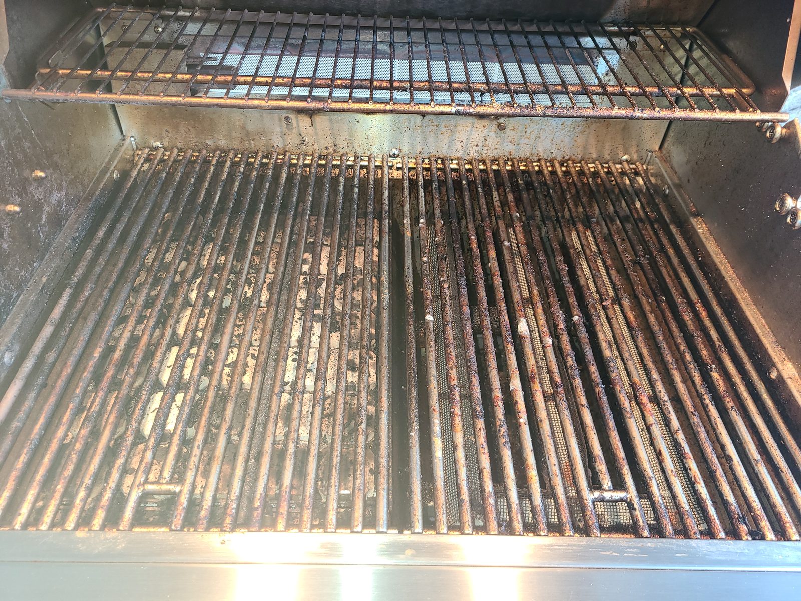 Severely rusted and grease-caked built-in grill grates before deep cleaning service in Sarasota FL