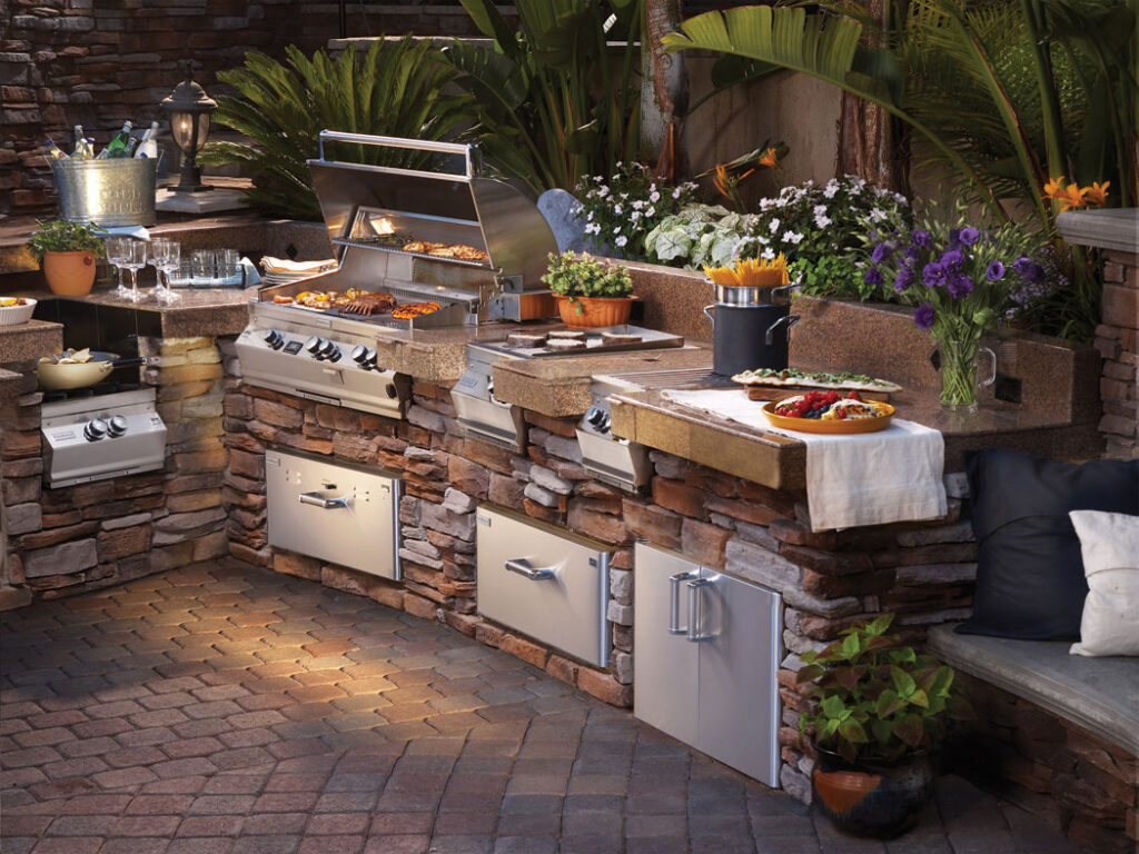 Beautiful outdoor kitchen with grills, side burners and food ready for grilling