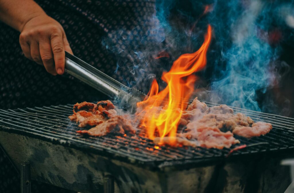 Man grilling meat on the bbq grill after being serviced by Xtreme Grill Clean in Sarasota, FL