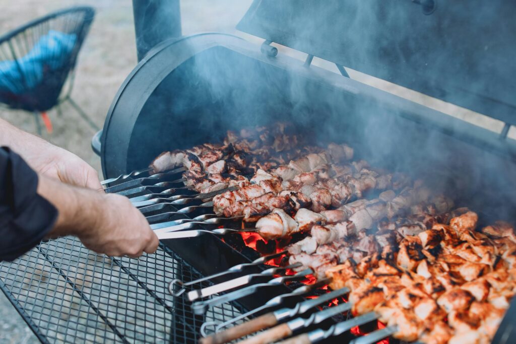 A man smoking meat on his clean smoker grill that was serviced by Xtreme Grill Clean in Lakewood Ranch. FL